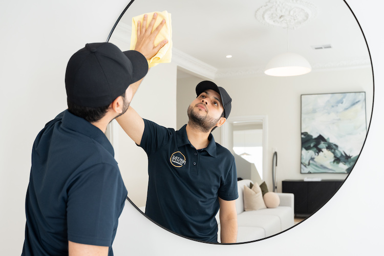 Housekeeper cleaning a mirror